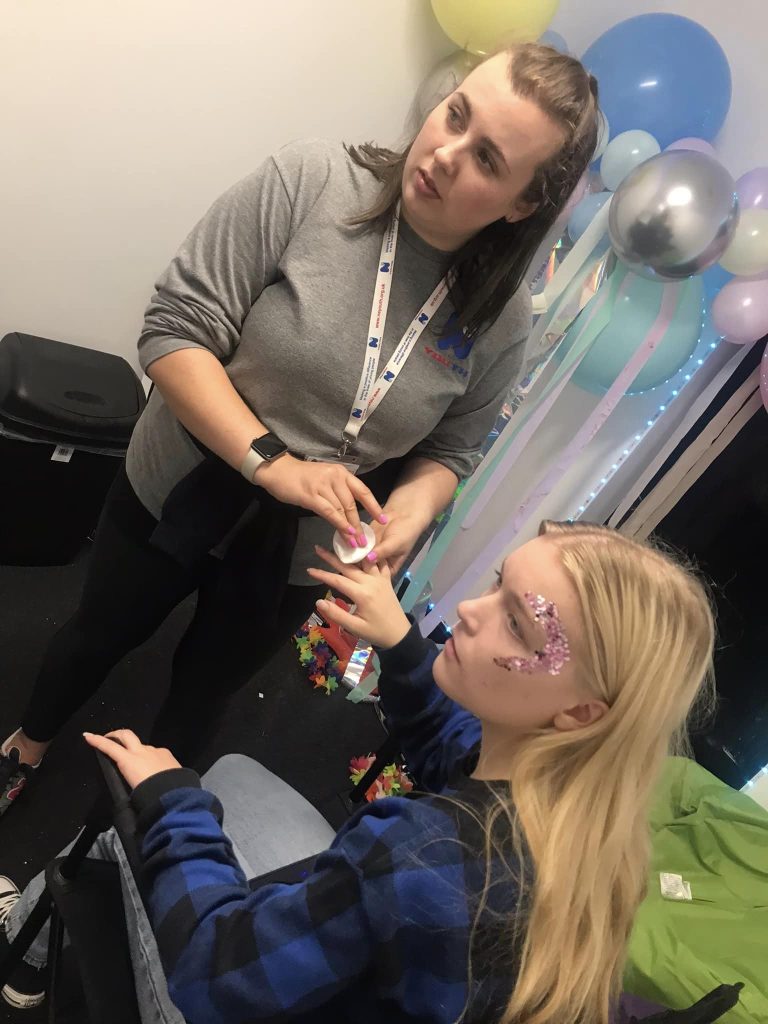 young girl getting her nails done by her youth worker