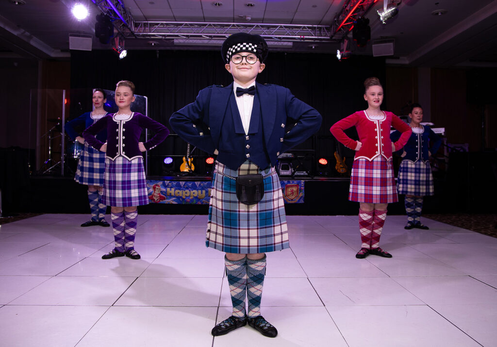 Dancers in traditional Scottish dress pose on the dance floor of a Burns Night Ball in Newcastle upon Tyne